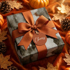 Cozy fall wrapping paper with orange ribbon and Cheers tag in autumn decor by Wrapped Studios.