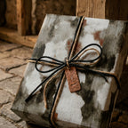 Rustic wrapping paper with a vintage distressed texture and leather bow by Wrapped Studios.