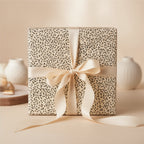 Elegant gift wrapped in botanical print wrapping paper with a satin ribbon bow.