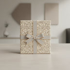 Elegant gift wrapped in modern patterned paper with gray ribbon and bow, for birthday or special occasion.