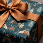 Teal gift wrap with unique insect pattern and gold ribbon for birthday or special occasion.