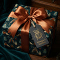 Elegant gift wrapped in luxury entomology-themed wrapping paper with a copper ribbon.