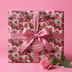 Luxury pink rose floral wrapping paper gift with satin bow, ideal for birthdays or Valentine's. Wrapped Studios.