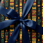 Close-up of elegant wrapping paper with botanical & candle design, tied with a blue satin ribbon.