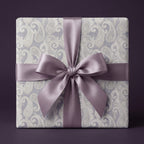 Elegant purple paisley wrapping paper with a luxury satin bow by Wrapped Studios.