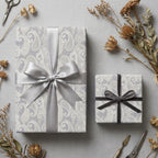 Elegant lavender paisley wrapping paper on gift boxes with grey satin ribbons by Wrapped Studios.