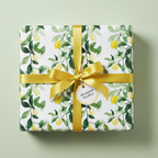 Square gift wrapped in lemon print paper with gold ribbon and bow.