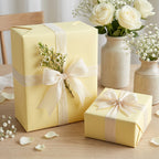 Pale yellow gift wrapping paper on boxes with ivory ribbon, perfect for wedding or baby shower presents.