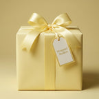Elegant lemon yellow wrapping paper with satin ribbon bow and gift tag.