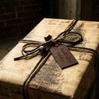 Vintage Christmas wrapping paper by Wrapped Studios on a rustic gift box with twine and bells.