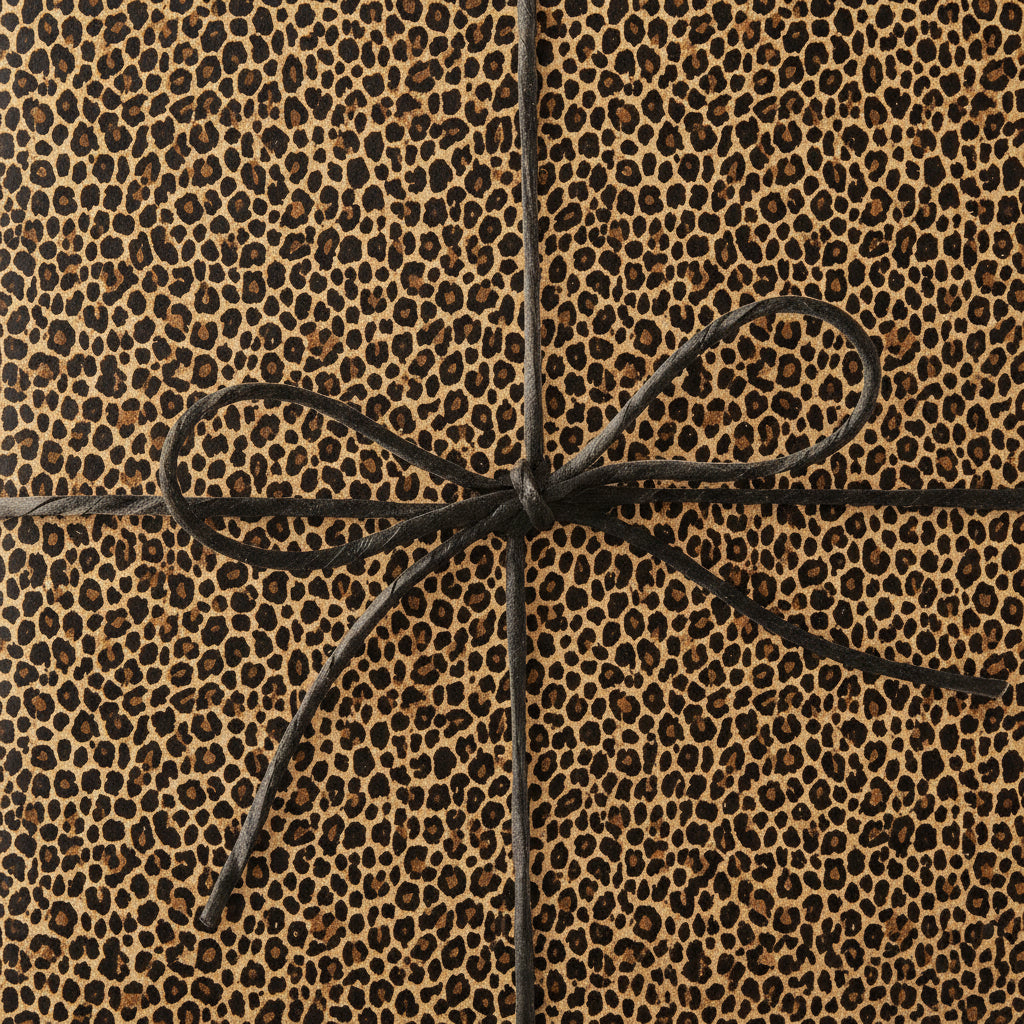 Leopard print wrapping paper on a gift box, tied with a simple black cord bow.