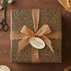 Square gift wrapped in luxe leopard print paper with a sheer gold ribbon and bow.