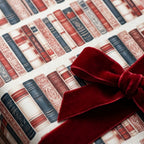 Vintage book wrapping paper with a luxury red velvet bow by Wrapped Studios, perfect for book lovers.