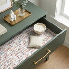 Bookish wrapping paper with watercolor bookshelf pattern lining a green drawer, by Wrapped Studios.