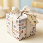 Book lover wrapping paper with watercolor books, cream bow, and "Read Me" tag by Wrapped Studios.