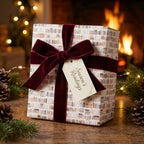 Bookish Christmas wrapping paper with a burgundy velvet bow by Wrapped Studios.