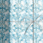 Wrapped gift in elegant floral wrapping paper with a silver string bow.