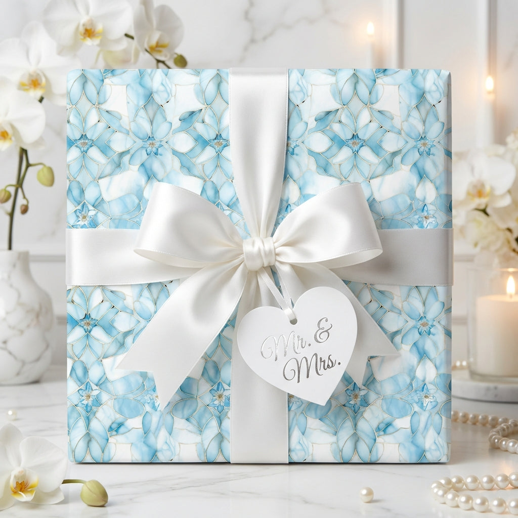 Elegant wedding gift wrapped in light blue floral paper with a white satin bow and "Mr. & Mrs." tag.