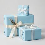 Light blue gift wrapping paper with white ribbon, perfect for baby shower or elegant birthday presents.