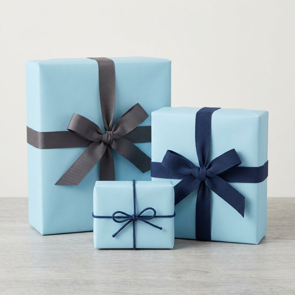 Three baby blue gift boxes wrapped with gray & navy ribbon, birthday presents, solid color wrapping paper.
