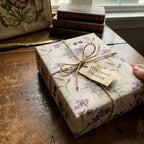 Wrapped Studios floral wrapping paper with twine bow, perfect for elegant birthday gifts.