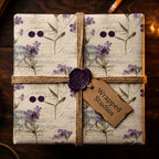Wrapped Studios floral wrapping paper with twine bow and purple wax seal on a square gift box.