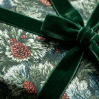 Luxury Christmas wrapping paper with pinecones and green velvet ribbon by Wrapped Studios.