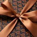 Elegant black and bronze damask wrapping paper with a copper satin bow, luxury gift wrap by Wrapped Studios.