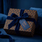 Luxury damask wrapping paper in navy and copper with a blue velvet bow by Wrapped Studios.