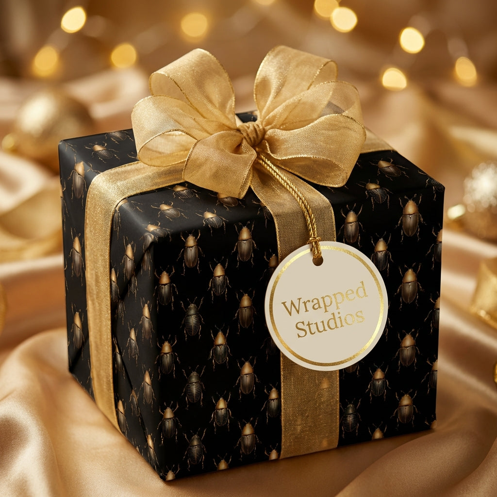 Elegant black gift box wrapped in gold ribbon and unique beetle print wrapping paper.
