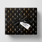 Unique gift wrap: Black wrapping paper with a gold beetle pattern and black ribbon.