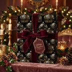 Elegant black Christmas gift wrap with gold ornament pattern and burgundy velvet ribbon.