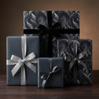 Elegant gifts wrapped in patterned luxury gift wrap with satin and velvet ribbon, stacked on a wooden surface.