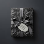 Elegant gift wrapped in gray floral wrapping paper with matching satin ribbon and gift tag.