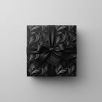 Elegant floral wrapping paper in black and grey, with matching satin bow, perfect for sophisticated gifts.