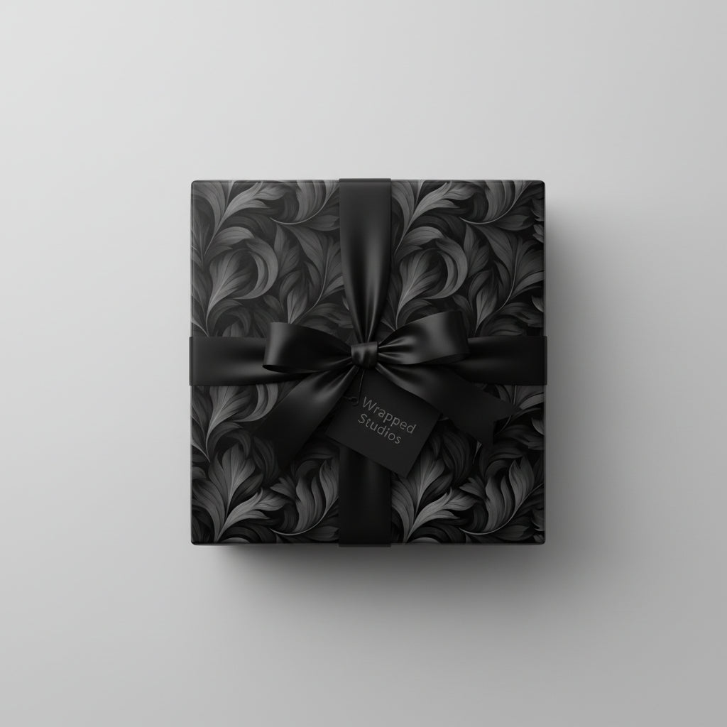 Elegant floral wrapping paper in black and grey, with matching satin bow, perfect for sophisticated gifts.