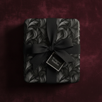 Elegant gift wrapped in black floral wrapping paper with a grosgrain bow, perfect for sophisticated presents.
