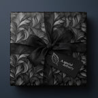 Elegant gift wrapped in black floral wrapping paper with a satin bow and "Special Delivery" tag.