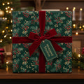 Elegant Christmas gift wrap with a festive red berry and evergreen floral pattern, tied with a velvet ribbon.