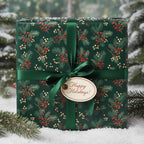 Elegant Christmas gift wrapped in dark green floral wrapping paper with red berries and a green ribbon.