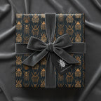 Elegant gift wrapped in beetle print wrapping paper with gray velvet ribbon on a velvet background.