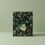 Elegant Christmas gift wrap with dark green floral paper and a satin bow.