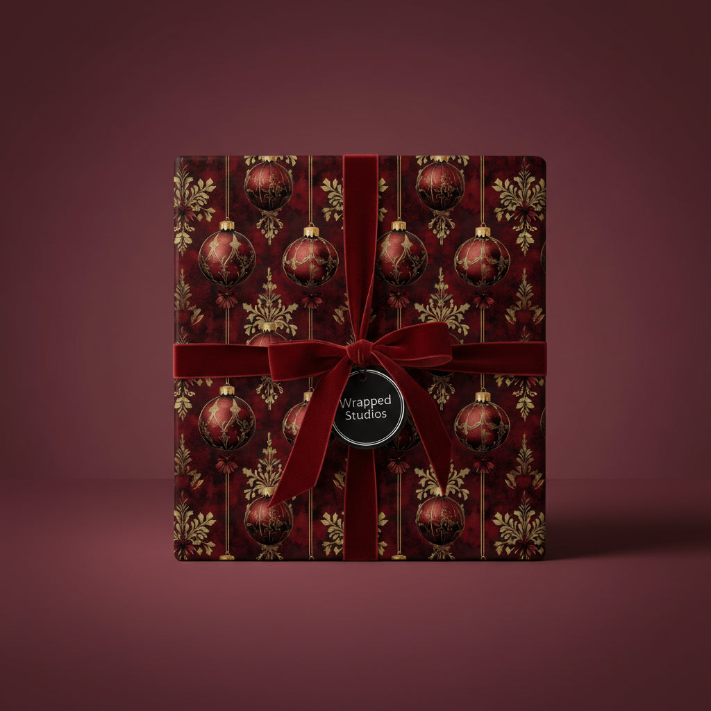Elegant Christmas gift wrapped in red and gold ornament-patterned wrapping paper with a velvet ribbon.