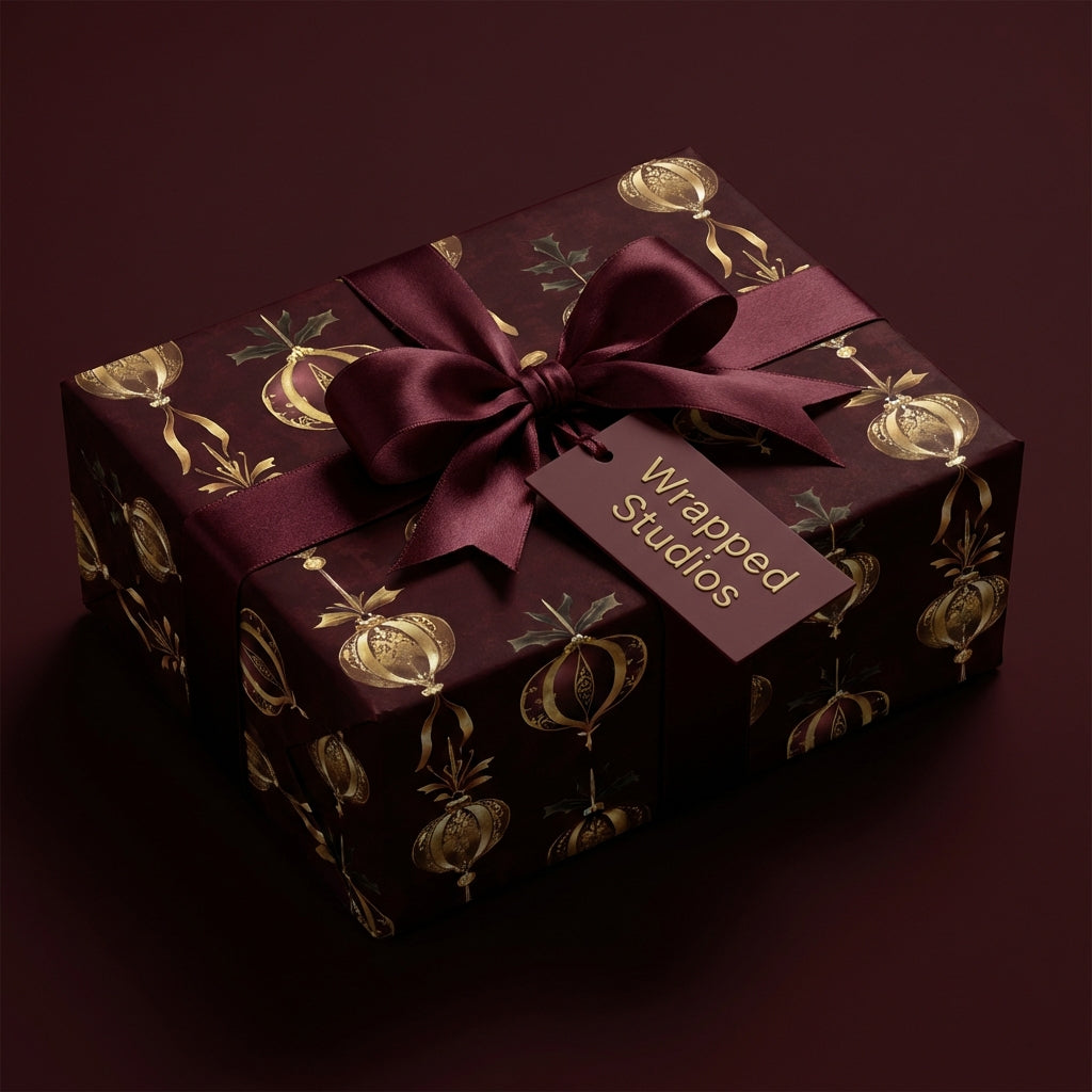 Elegant holiday gift beautifully wrapped in burgundy paper with gold ornament design from Wrapped Studios.