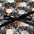 Elegant floral wrapping paper in black, white, and copper with a black satin ribbon.
