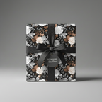 Elegant gift wrapped in dark floral wrapping paper with a satin black ribbon and bow.