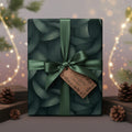 Elegant Christmas gift wrapped in green floral wrapping paper with satin ribbon and a "Thoughtful Gesture" tag.