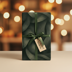 Elegant gift box wrapped in dark green botanical wrapping paper with ribbon and gift tag.