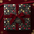 Square gift wrapped in black patterned paper with red/gold dots and velvet ribbon; elegant gift wrap.