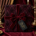 Elegant burgundy gift wrap with damask pattern and velvet ribbon.